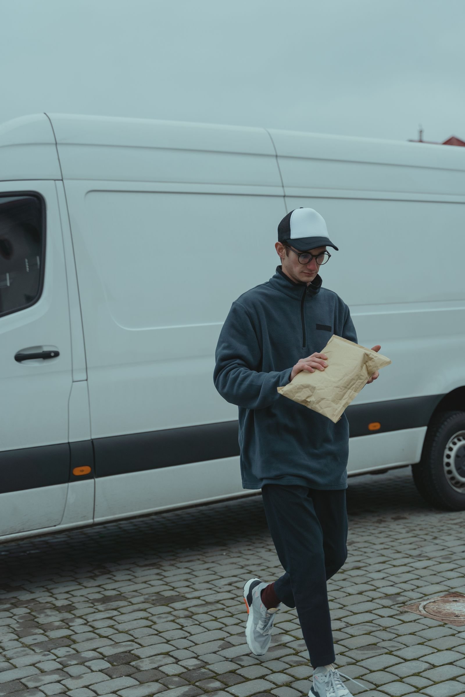 Courier delivering a package next to a van