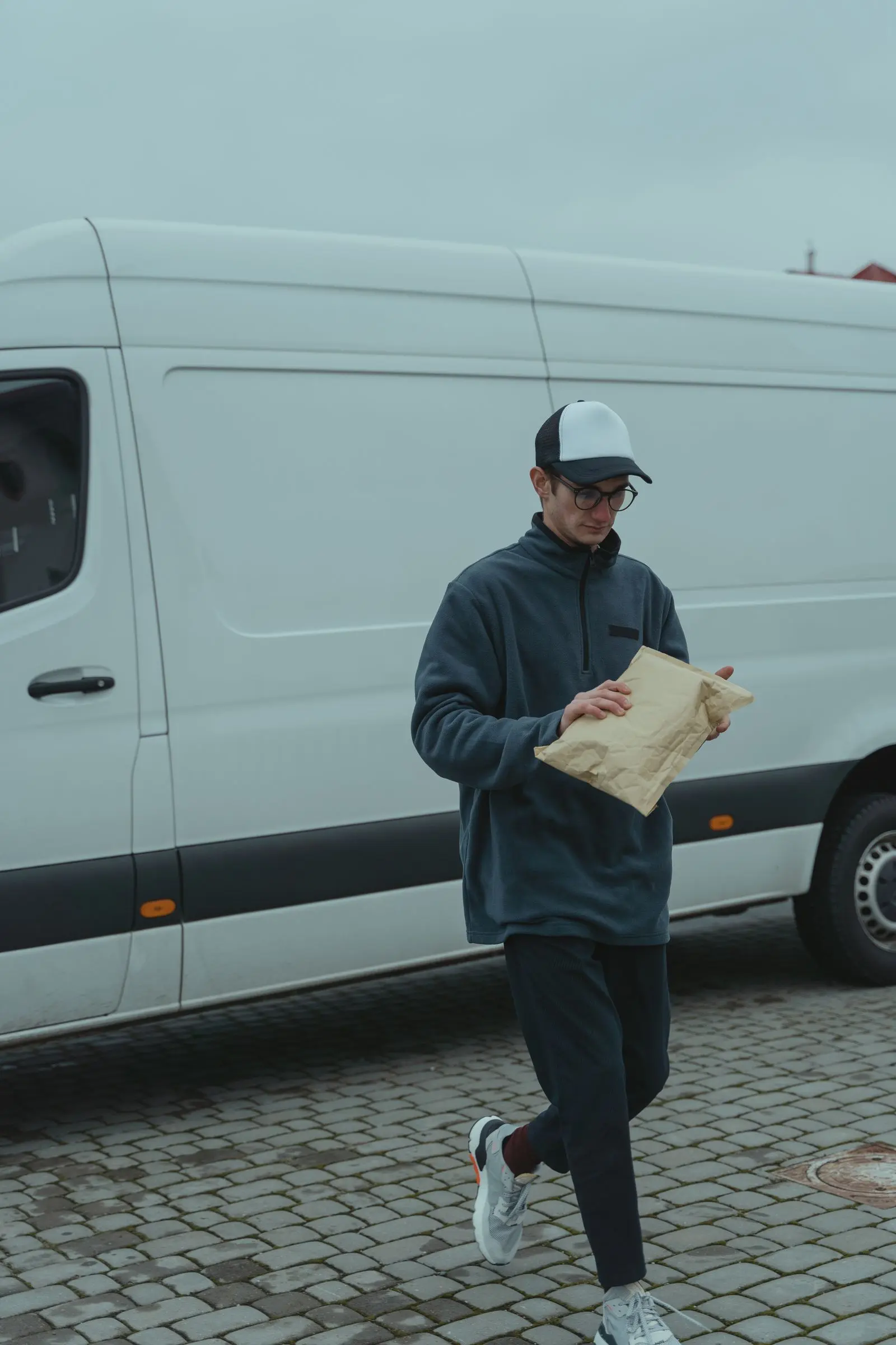 Courier delivering a package next to a van