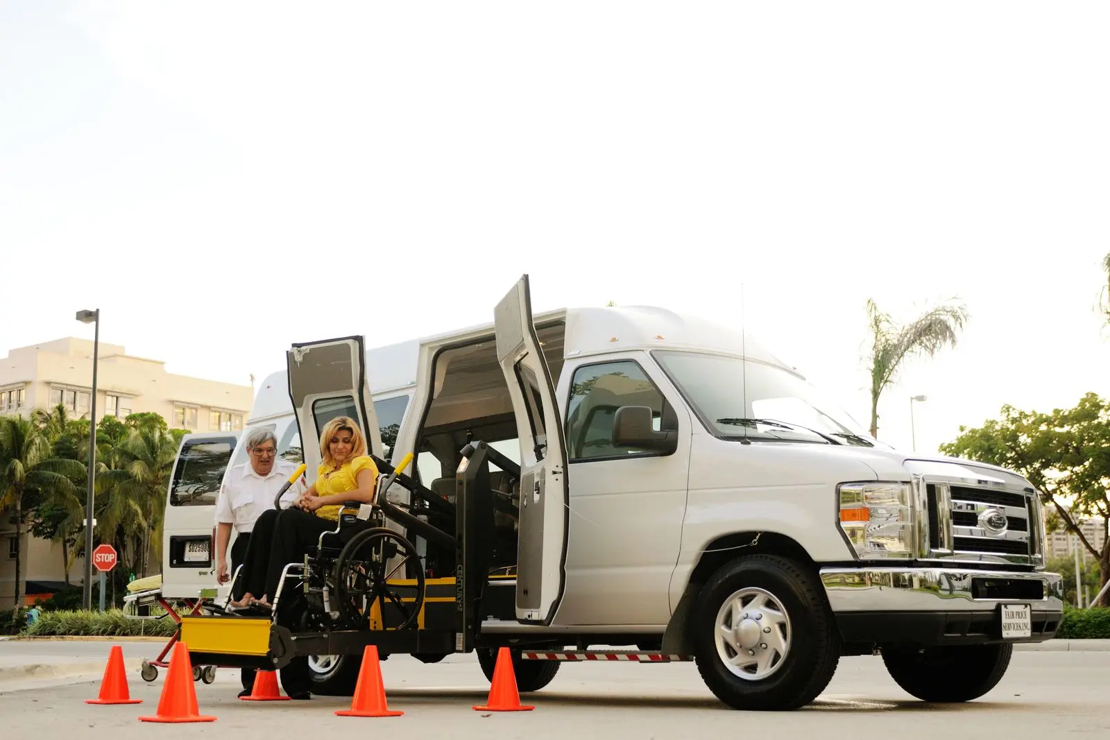 Driver assisting a wheelchair passenger into an accessible van